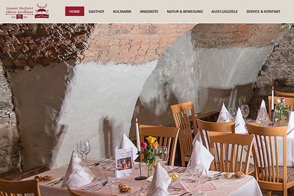 Screenshot der Website mit Headerbild: Der Weinkeller des Gasthofs mit Steinwänden und helbraunen Holzstühlen sowie gedeckten Tischen.